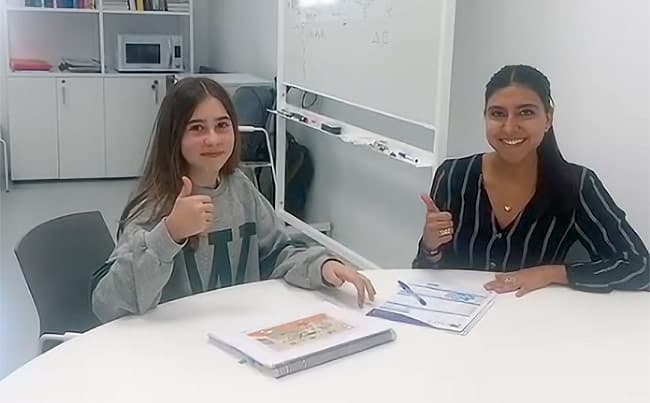 Maestra acompañando a un alumno durante la lectura
