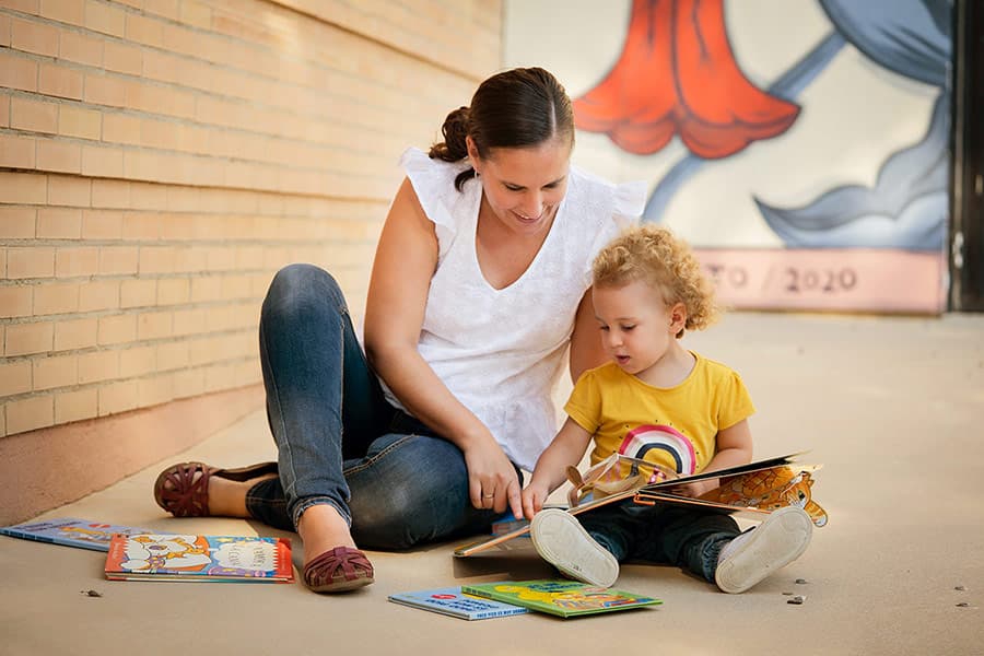 Adulta leyendo un cuento con una niña pequeña