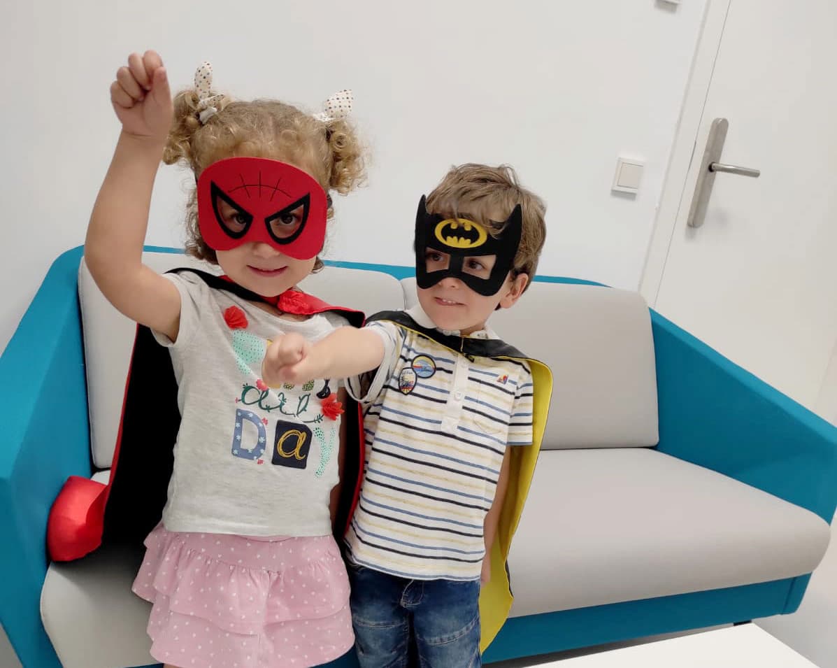 Niña con un gorro de electroencefalografía junto a su familia en el laboratorio